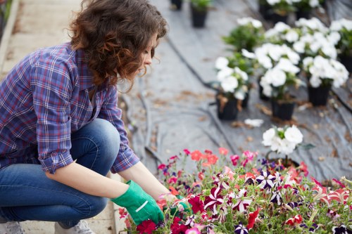 Landscaper assessing a garden work area with safety equipment